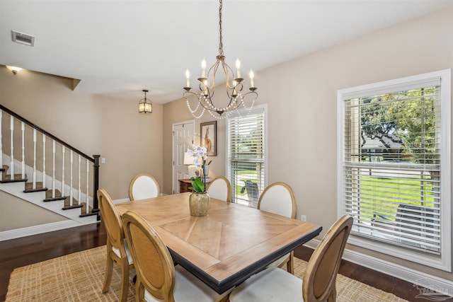 dining area with a notable chandelier, dark hardwood / wood-style flooring, and a wealth of natural light