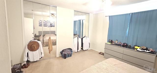 carpeted bedroom featuring ceiling fan and a closet