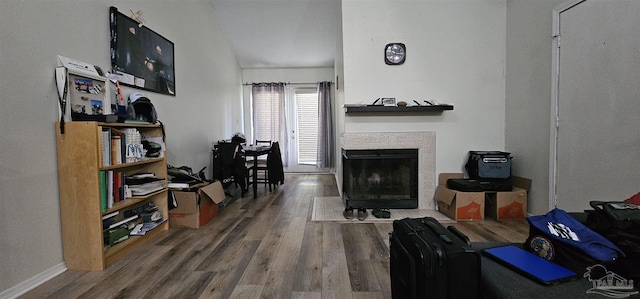 living room featuring a tile fireplace and hardwood / wood-style floors