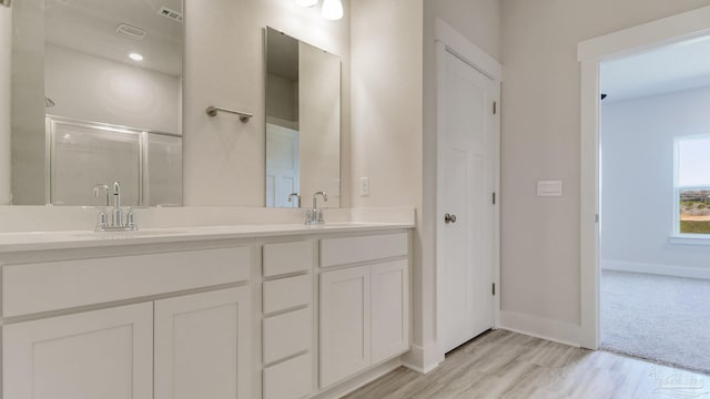 1674 Amaya Ln, Gulf Breeze, FL 32563 - bathroom featuring double vanity, a stall shower, baseboards, and wood finished floors