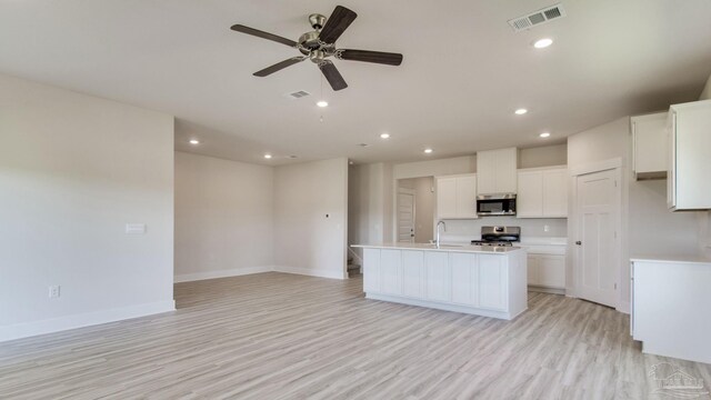 1674 Amaya Ln, Gulf Breeze, FL 32563 - kitchen featuring appliances with stainless steel finishes, open floor plan, a center island with sink, a ceiling fan, and light countertops