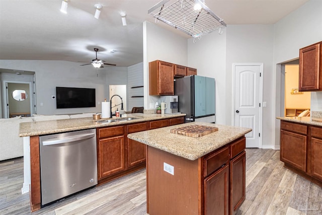 kitchen featuring ceiling fan with notable chandelier, sink, light hardwood / wood-style floors, a kitchen island, and stainless steel appliances