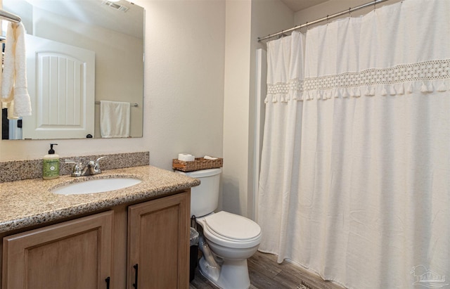 bathroom with vanity, wood-type flooring, and toilet