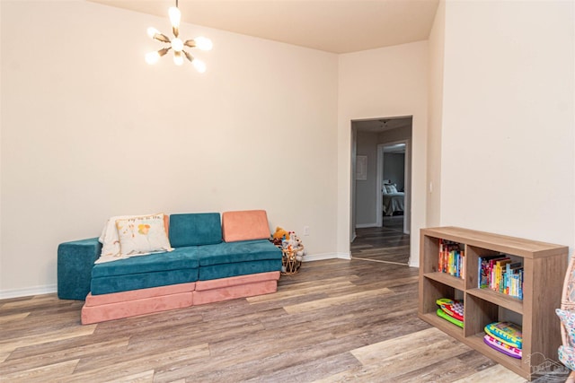 sitting room with hardwood / wood-style flooring and an inviting chandelier