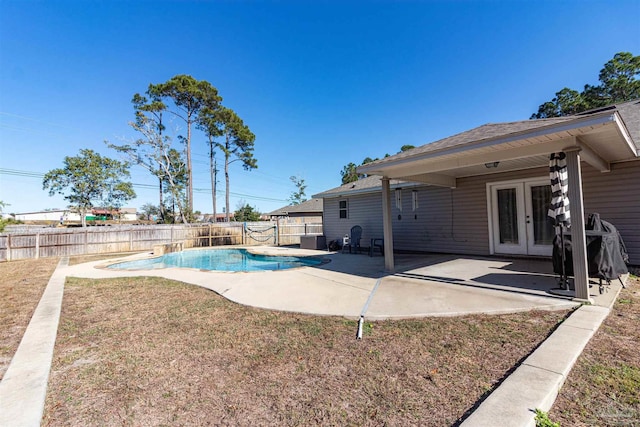 view of pool with a lawn, french doors, cooling unit, and a patio