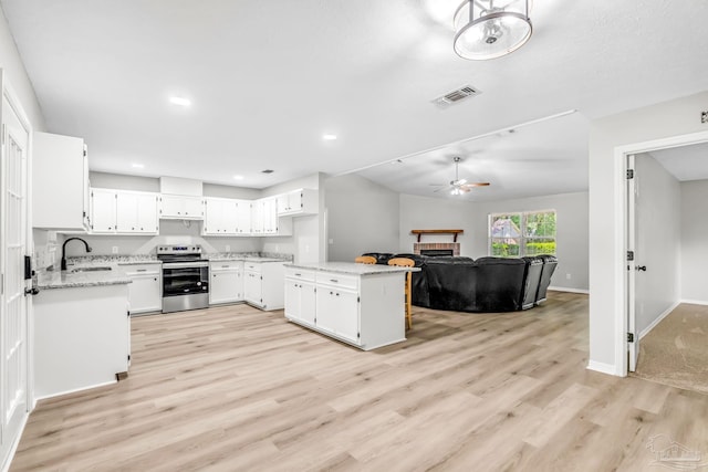 9001 Thompson Dr, Pensacola, FL 32534 - kitchen with electric range, a sink, ceiling fan, light wood-type flooring, and white cabinetry