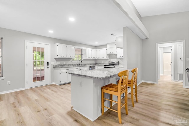 9001 Thompson Dr, Pensacola, FL 32534 - kitchen with stainless steel appliances, light wood-style flooring, white cabinets, a breakfast bar, and recessed lighting