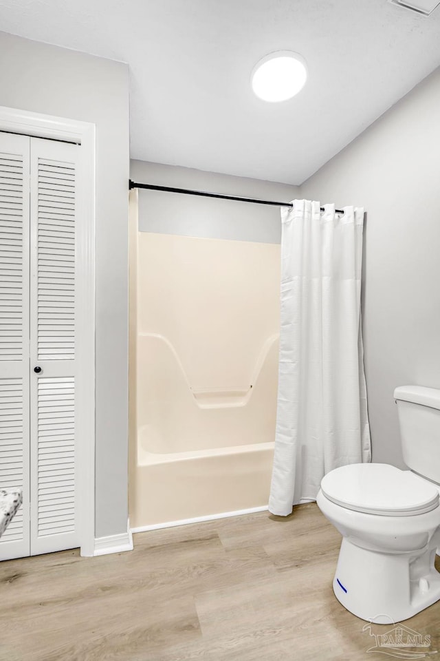 9001 Thompson Dr, Pensacola, FL 32534 - full bath with toilet, wood finished floors, a closet, and shower / tub combo with curtain