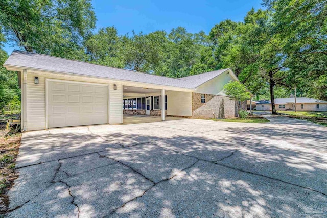 9001 Thompson Dr, Pensacola, FL 32534 - view of home's exterior featuring concrete driveway, a carport, and a garage