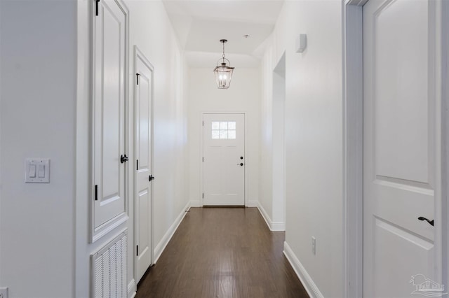 entryway featuring dark wood-type flooring and a notable chandelier