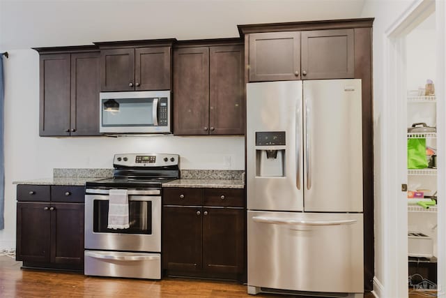 kitchen with dark brown cabinetry and appliances with stainless steel finishes