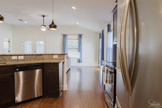 kitchen featuring light stone countertops, dark brown cabinetry, stainless steel appliances, and lofted ceiling