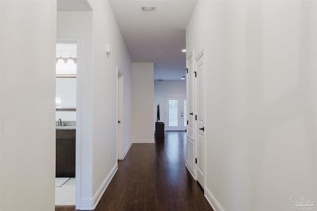 corridor with dark hardwood / wood-style floors and sink