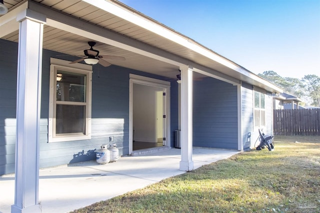 doorway to property with a lawn, a patio area, and ceiling fan