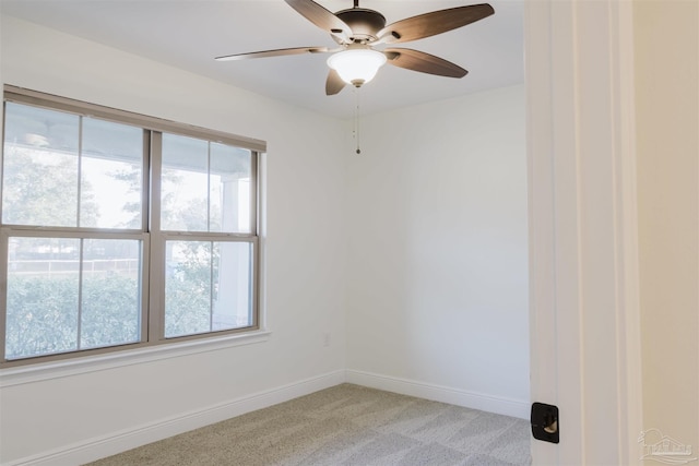 empty room with ceiling fan and light carpet