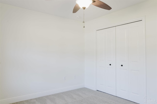 unfurnished bedroom featuring ceiling fan, light carpet, and a closet