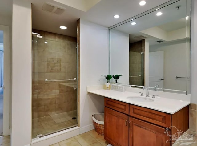 bathroom featuring tile patterned flooring, an enclosed shower, and vanity