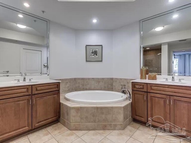 bathroom featuring tile patterned flooring, vanity, and shower with separate bathtub