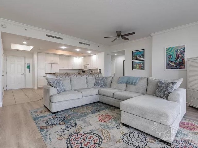 living room featuring ornamental molding, ceiling fan, and light hardwood / wood-style floors