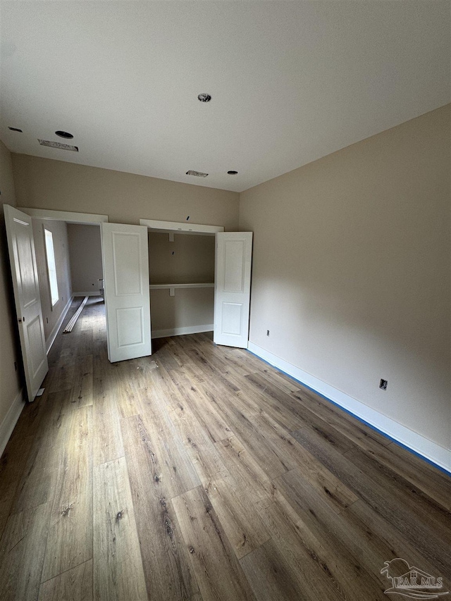 unfurnished bedroom with hardwood / wood-style flooring and a closet