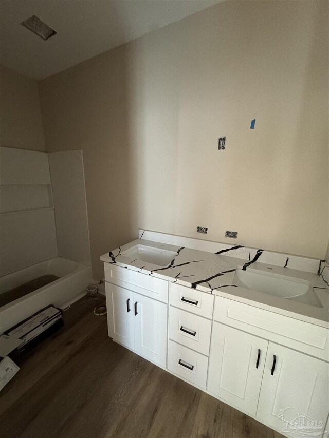 bathroom with a washtub and hardwood / wood-style flooring