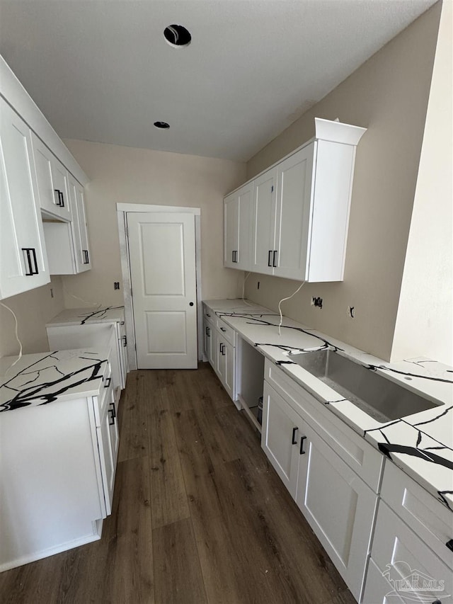 kitchen featuring white cabinetry, light stone counters, and dark hardwood / wood-style floors