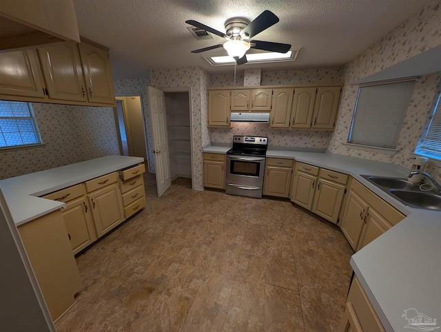 kitchen with ceiling fan, stainless steel electric stove, sink, and a textured ceiling