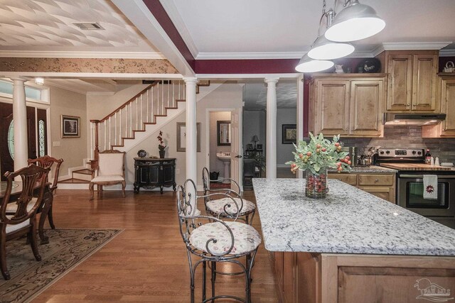 kitchen with crown molding, decorative columns, stainless steel electric range, and hardwood / wood-style flooring