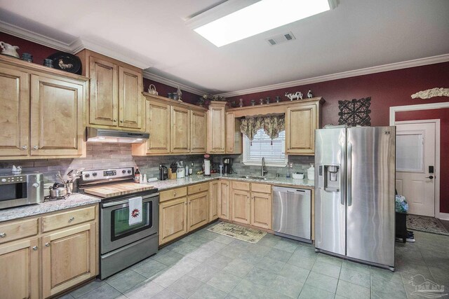 kitchen featuring sink, backsplash, appliances with stainless steel finishes, crown molding, and light stone countertops