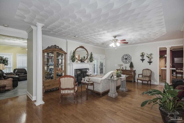 living room with wood-type flooring, ceiling fan, plenty of natural light, and ornate columns