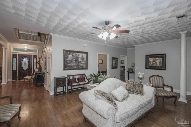 living room featuring decorative columns, ornamental molding, dark hardwood / wood-style flooring, and ceiling fan