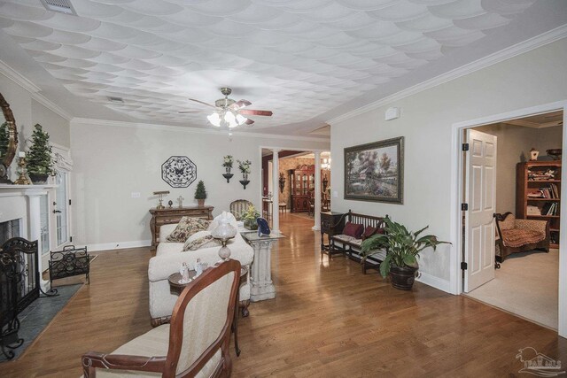 living room with ornamental molding, ceiling fan, and hardwood / wood-style floors