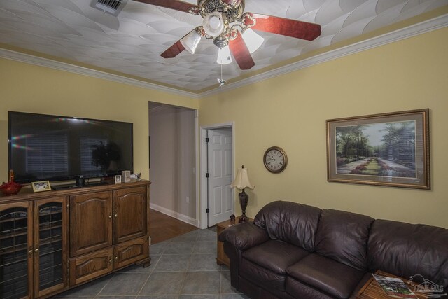 living room featuring ornamental molding, ceiling fan, and dark tile patterned flooring