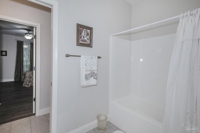 bathroom featuring ceiling fan, hardwood / wood-style flooring, and shower / tub combo