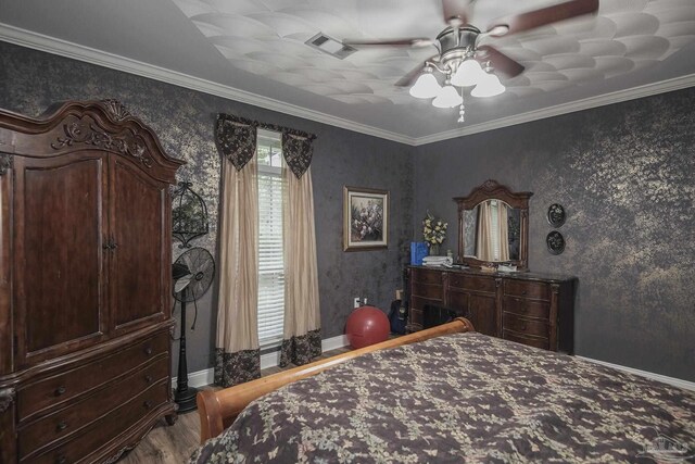 bedroom featuring ceiling fan, hardwood / wood-style floors, and crown molding