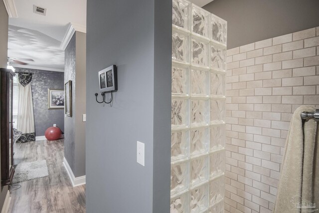 bathroom featuring wood-type flooring, ornamental molding, and ceiling fan