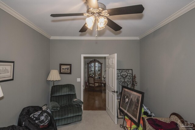 living area with ornamental molding, ceiling fan, and light colored carpet