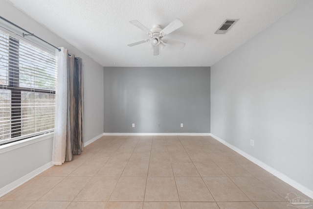 tiled spare room featuring a textured ceiling and ceiling fan