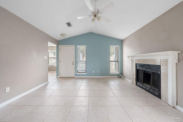 unfurnished living room featuring a tiled fireplace, ceiling fan, lofted ceiling, and light tile patterned floors