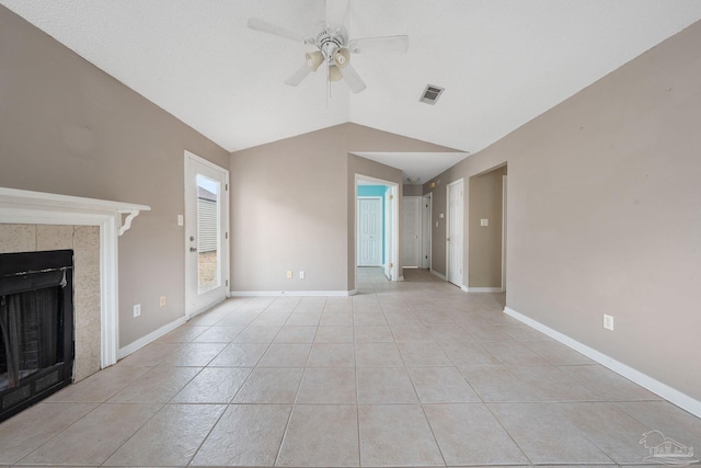 unfurnished living room featuring light tile patterned flooring, a tile fireplace, ceiling fan, and vaulted ceiling