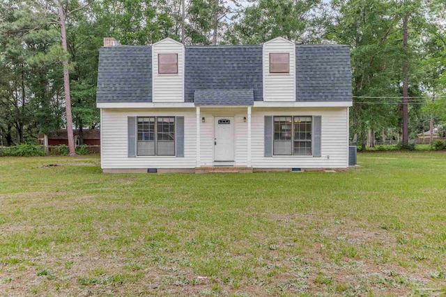 view of front of property with a shingled roof, a front lawn, and view of wooded area