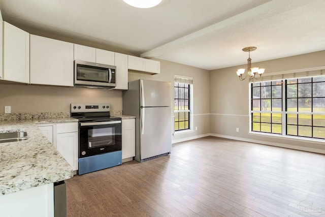 kitchen with stainless steel appliances, light wood-type flooring, a chandelier, white cabinetry, and pendant lighting