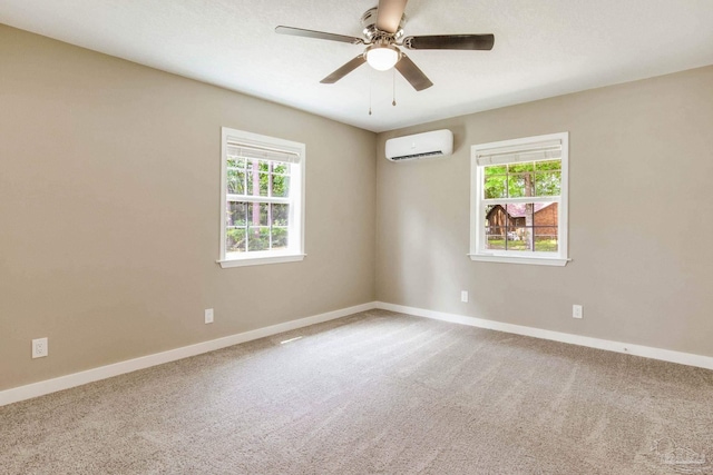 unfurnished room with a wall mounted AC, plenty of natural light, and baseboards