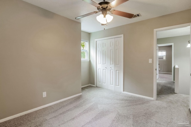 unfurnished bedroom featuring carpet, baseboards, a closet, and ceiling fan