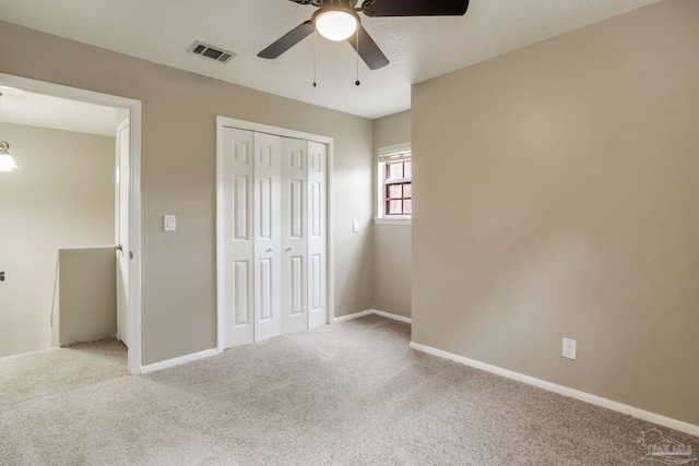 unfurnished bedroom featuring carpet floors, a closet, ceiling fan, and baseboards