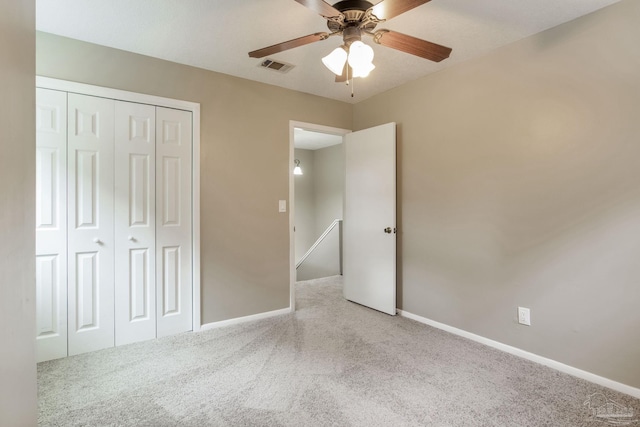 unfurnished bedroom featuring carpet, baseboards, a closet, and ceiling fan