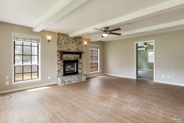 unfurnished living room with beamed ceiling, baseboards, and wood finished floors