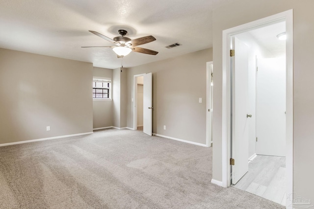 empty room with a ceiling fan, carpet floors, and baseboards