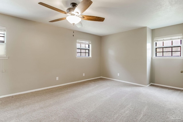 empty room featuring ceiling fan, light carpet, and baseboards
