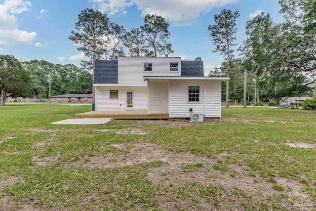 rear view of property featuring a wooden deck, a yard, and a shingled roof